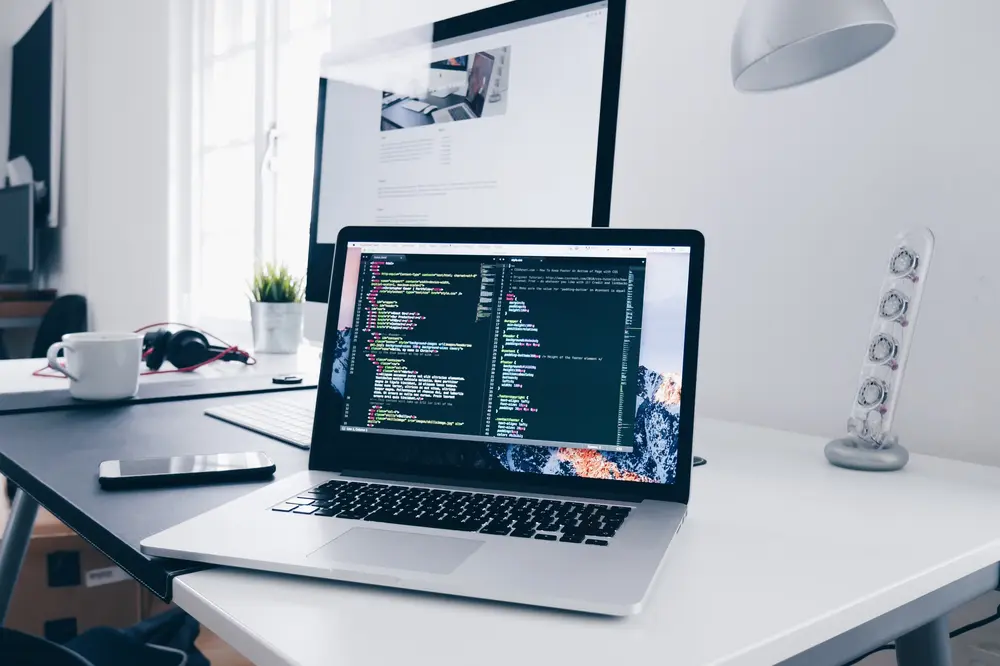 Open MacBook displaying code on screen